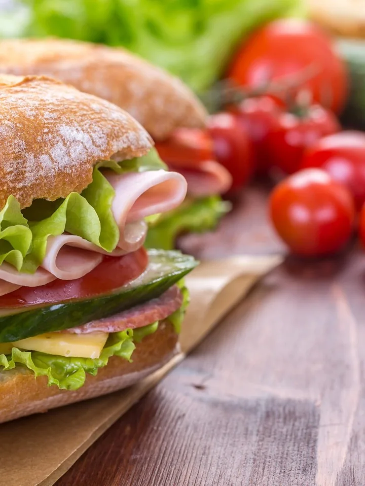 A ciabatta sandwich filled with ham, cheese, lettuce, tomato and cucumber
