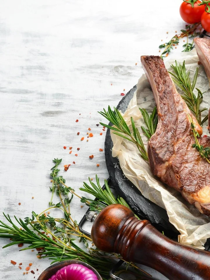 Seared chops resting on slate with rosemary, thyme and cracked pepper